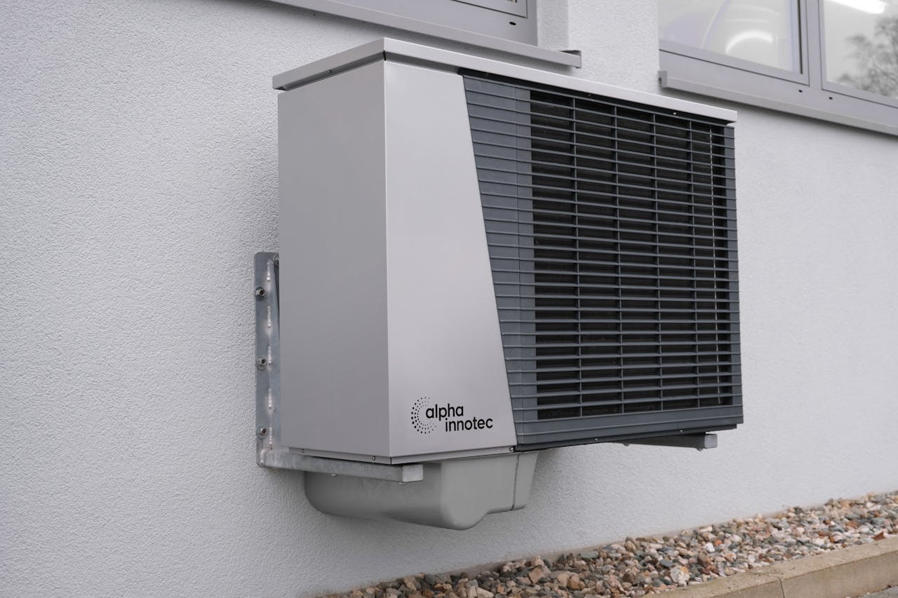 why-choose-us Outdoor air conditioning unit mounted on a residential building exterior.